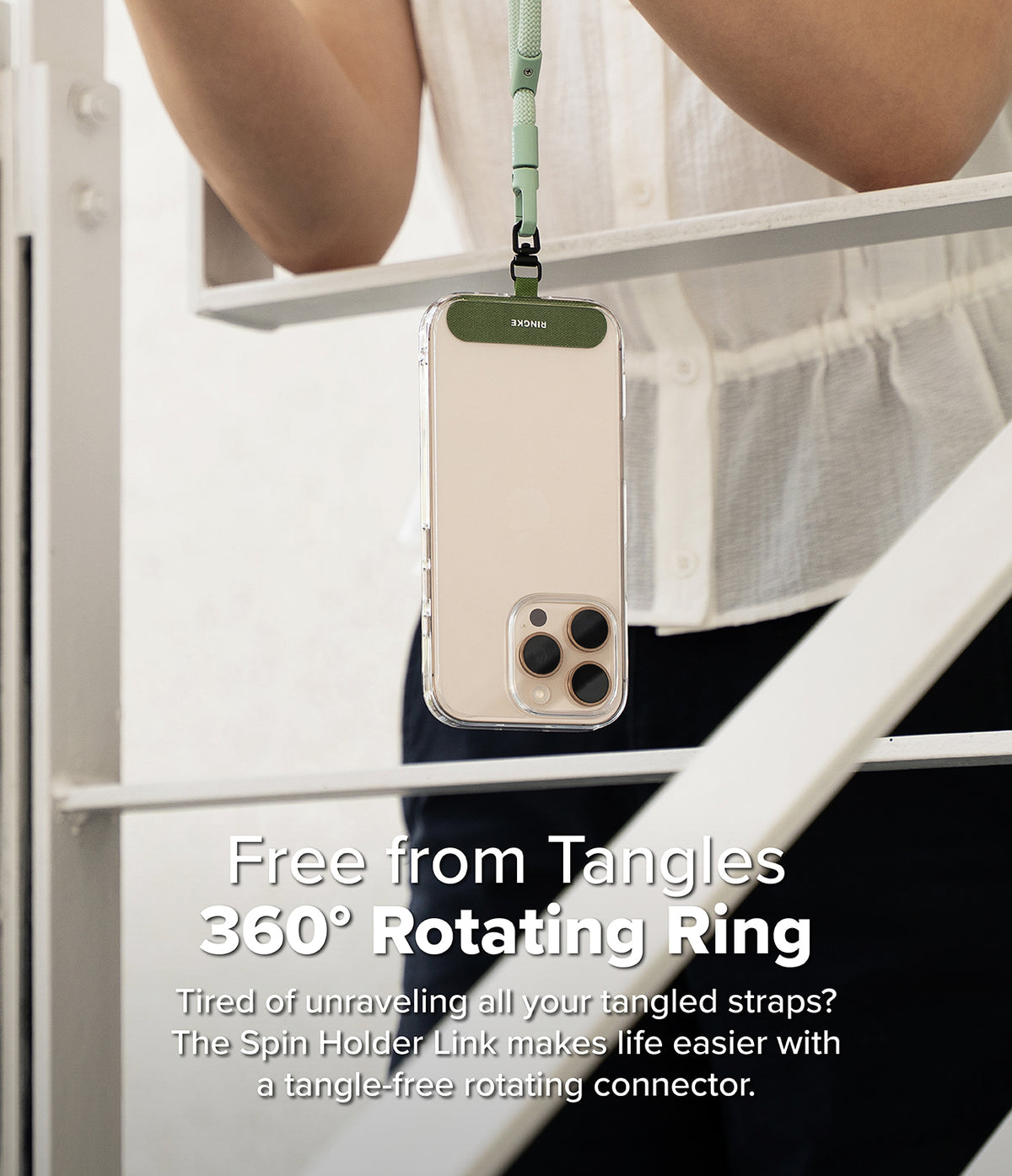 Holder Link Spin - A smartphone hanging from a sage green lanyard with a 360-degree rotating connector to prevent tangles.