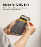 Card Holder | Stand Wallet Magnetic - Hands holding a phone case with a grey magnetic wallet storing three cards.