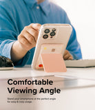 Card Holder | Stand Slot - A person using a phone with a pink card holder stand attached, propped up on a desk.