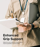 Card Holder | Stand Slot - Person holding a phone with a pink magnetic card holder acting as a finger grip while carrying a laptop.