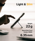 Card Holder | Stand Slot - A finger touches a smartphone propped up by a slim, black stand on a desk with weight and width specs.