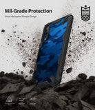Galaxy A50 Case | Fusion-X - Blue camo phone case with black bumper, surrounded by flying debris, highlighting military-grade protection.