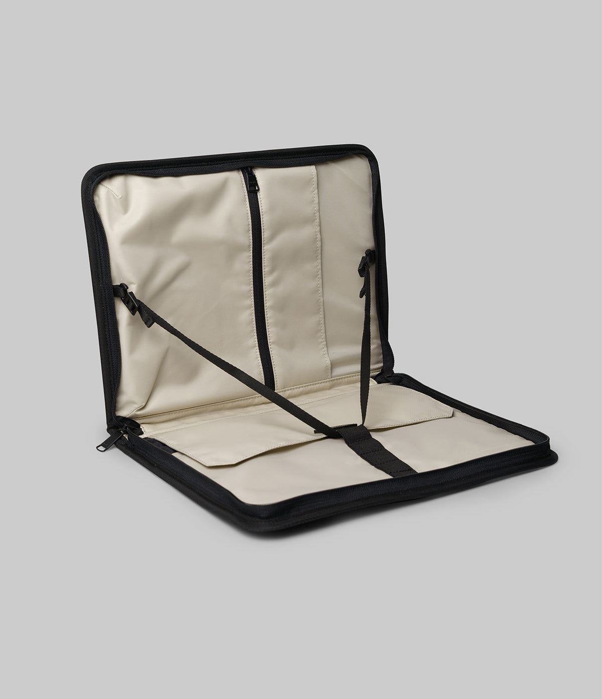 Pad Pouch | Smart Zip Pouch - Open black zippered case with cream interior, featuring internal pockets and adjustable support straps.