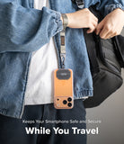 Holder Link Tactical Webbing Hand Strap - A smartphone hanging from a tactical webbing strap attached to a person's wrist.