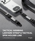 Holder Link Tactical Webbing Lanyard Strap - A tactical webbing lanyard strap with a black tactical spin holder link, shown attached to a smartphone case on a dark gray textured surface. The Ringke brand name is visible in the bottom right corner.