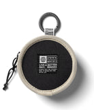 Mini Pouch | Tambourine Bag - Round black pouch with beige trim, carabiner clip, and a branded patch featuring coordinates.