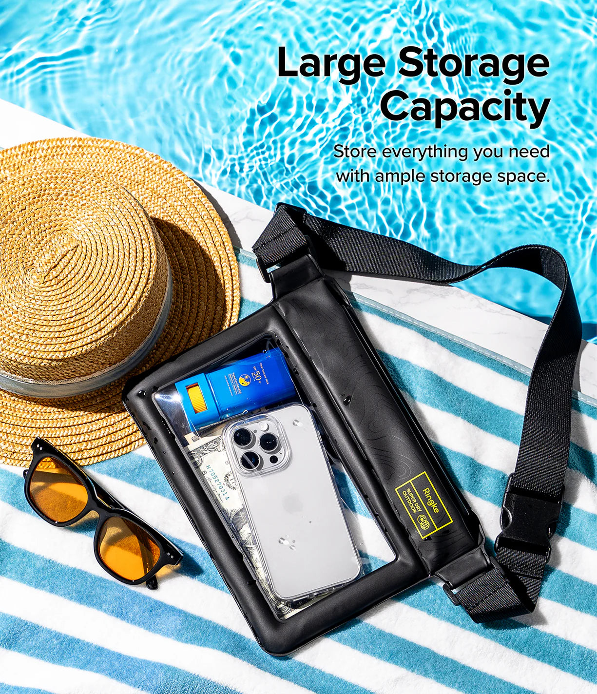 Banana / Navy Stripes Floating Strap & Waterproof Sling Bag | Black waterproof bag with phone and sunglasses on a striped towel by a poolside, emphasizing large storage capacity.