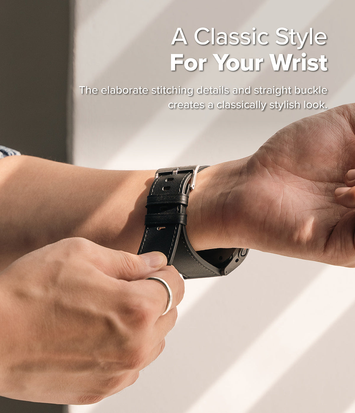 Watch Lug 24mm | Leather One Basic Bold - Close-up of a person fastening a black leather watch strap with white stitching.
