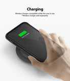 iPhone 11 Case | Fusion Matte - Hand placing an iPhone 11 in a black case onto a wireless charging pad showing 100% charge.