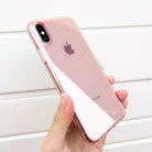 iPhone X Case | Air - A hand holding a rose gold iPhone X in a clear, slim protective case against a white slatted background.