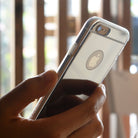 iPhone 6s / 6 Case | Mirror - Hand holding an iPhone with a clear, reflective mirror-finish case against a blurred background.