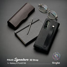 Galaxy Z Fold 3 Case | Folio Signature EZ Strap - Black textured phone case with strap, notebook, pen, and glasses.
