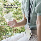 Lanyard Strap | Black - Person wearing a black lanyard strap attached to a clear phone case while holding a plastic cup.