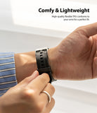 Apple Watch 42·41·40·38 mm | Rubber One Band - A person adjusting a black ribbed rubber watch band on their wrist.