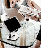 Iron Tablet Stand - A silver adjustable tablet stand holding a tablet on a glass coffee table in a modern living room.