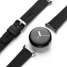 Google Pixel Watch | Rubber One Band - A black circular smartwatch face surrounded by detached, ribbed black rubber watch straps.